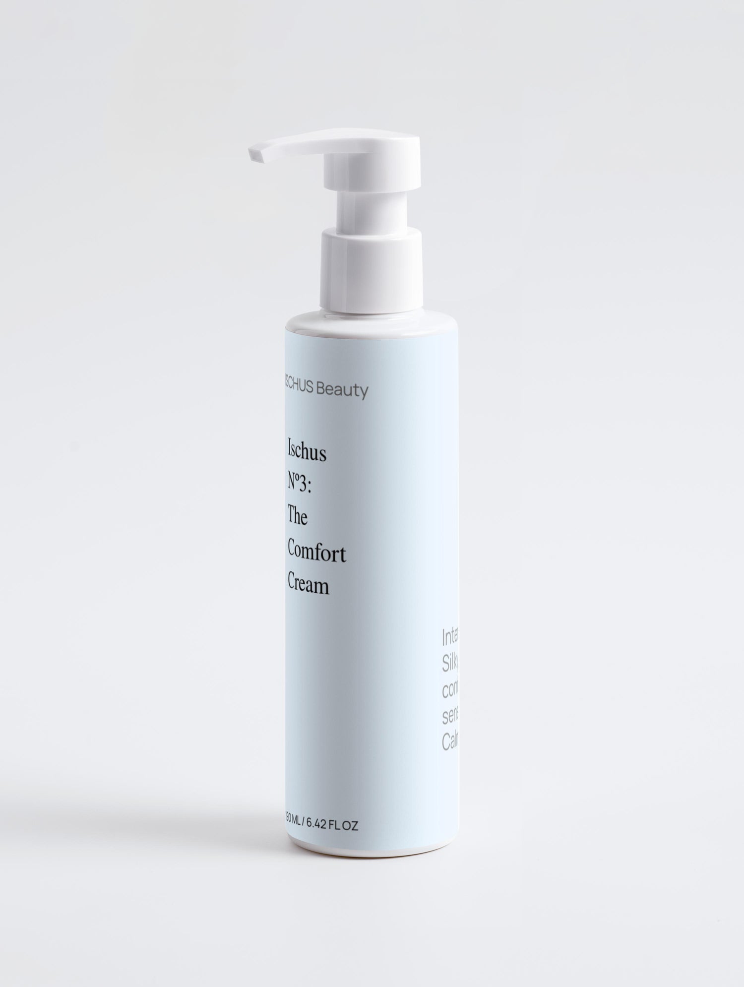 A white pump bottle labeled "The Comfort Cream - Sensitive Skin Body Cream" stands upright against a plain light gray background. The minimalist label features black text on a pale blue panel.