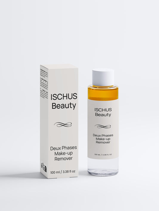 A bottle of Deux Phases Make-up Remover, featuring a clear, fragrance-free, dual-layer formula for all skin types, stands beside its box. Both have white packaging with sleek black text.